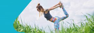 blonde woman with tattoos doing yoga in a field